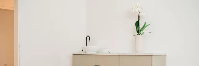 Sideboard mit Aufsatzwaschbecken und einer Orchidee