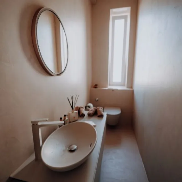 Gäste-WC mit rundem Spiegel, Aufsatzwaschbecken und Duftstäbchen